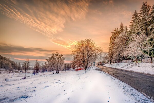 Winterlandschaft mit verschneiten Straßen und Sonnenuntergang