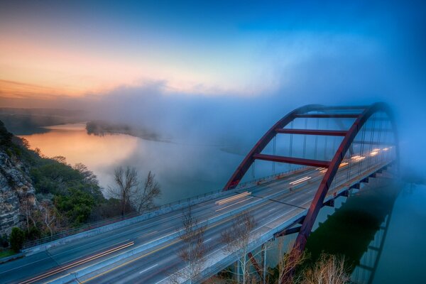 Neblige Landschaft. Brücke über den Fluss