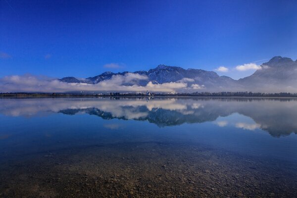 The sky is reflected in Lake Forggensee