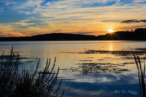 Sunset over the hills of a clear lake