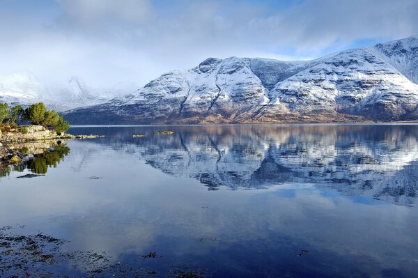 Die Abendberge im Schnee spiegeln sich im See wider