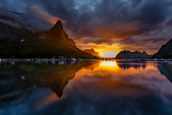 Puesta de sol vespertina y montañas que se reflejan en el lago