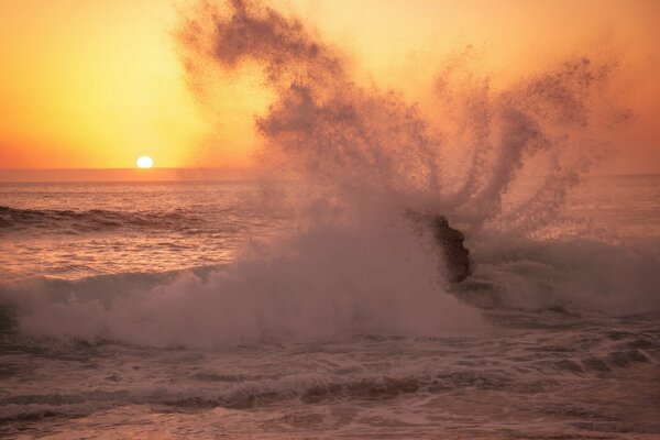 Amanecer en el océano. Salpicaduras de las olas