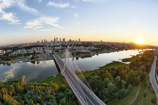 Puente sobre el río con puesta de sol y bosque