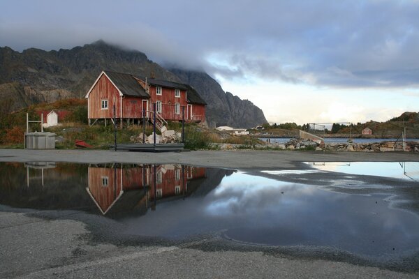 The house after the autumn rain on the background of a gray cloud