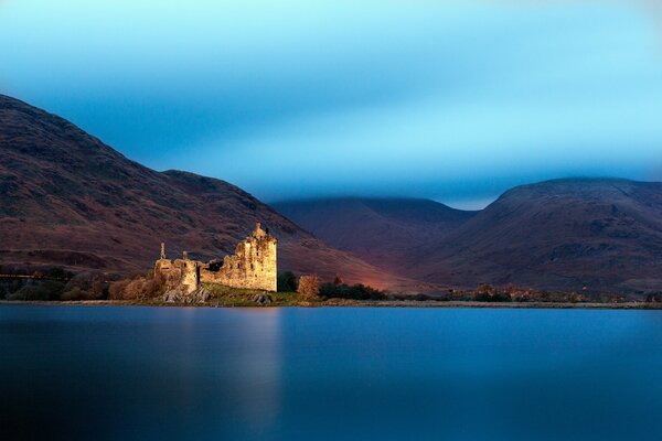 A lake in Scotland with a castle in the background