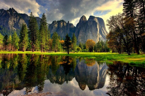 Der herbstliche kalifornische Wald spiegelt sich in einem See im Yosemite Park wider