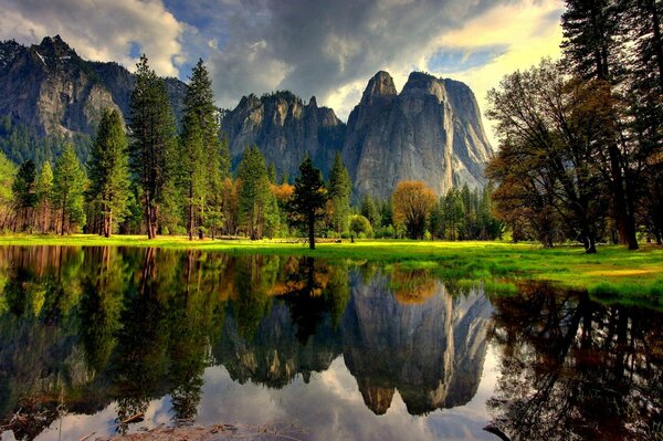 Une forêt californienne automnale se reflète dans un lac du parc Yosemite