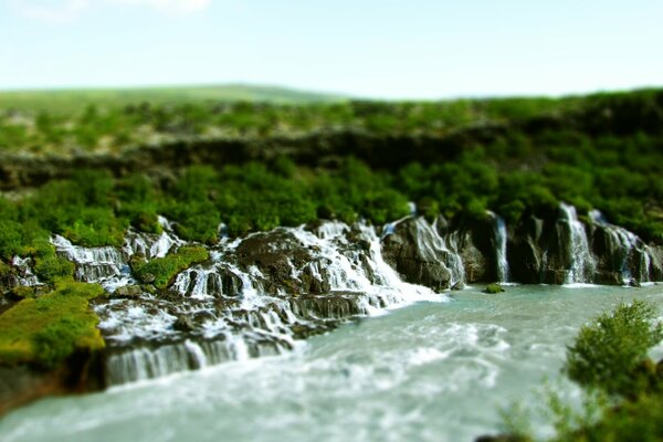 Wasserfälle , die in einen Bergfluss münden