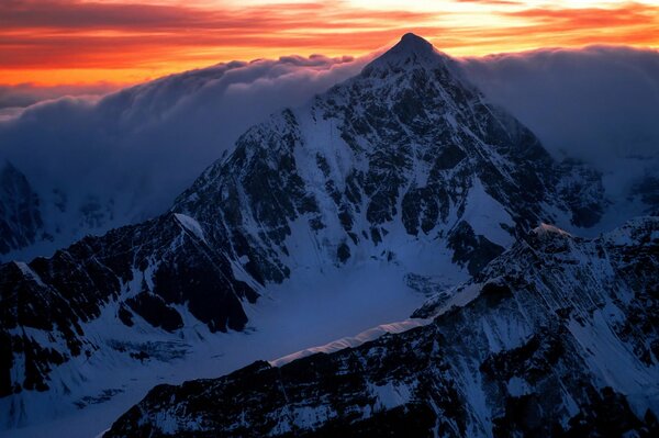 Sunrise at the top of a mountain with snow-white clouds