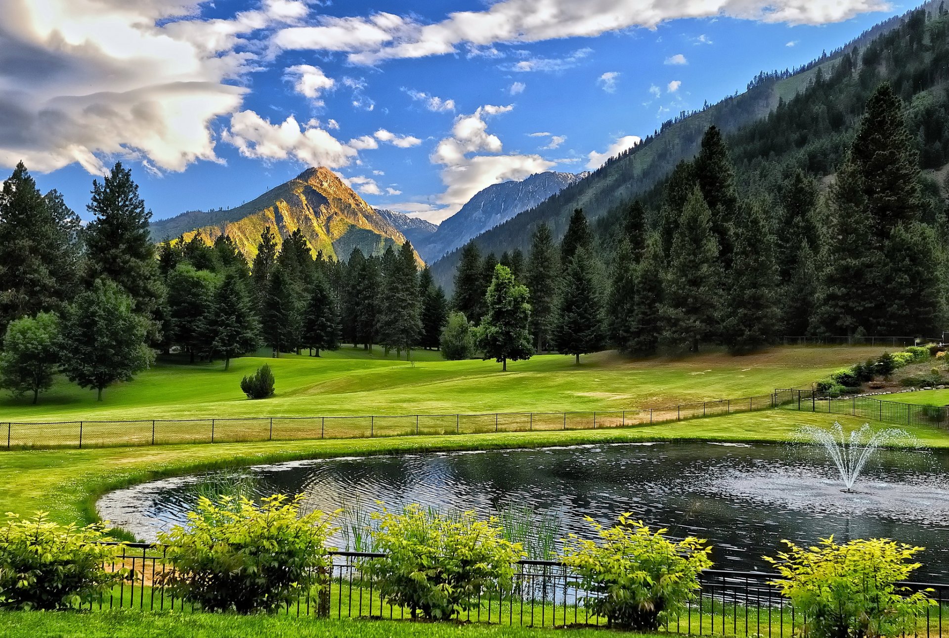 teich brunnen berge bäume zaun büsche