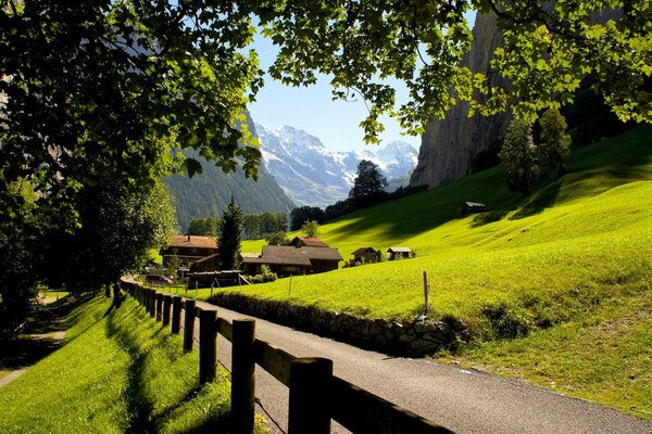 The road to the mountain village with fields