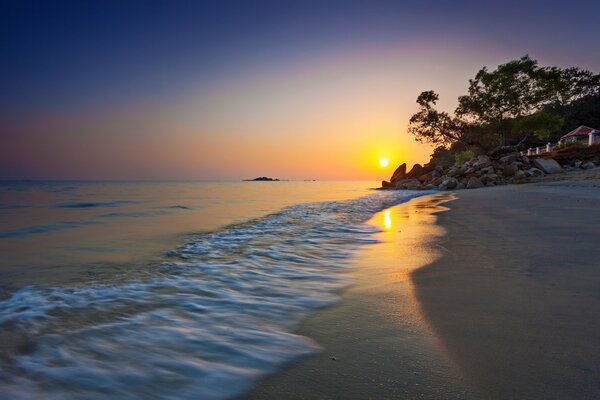 Puesta de sol dorada en la costa del estrecho de Malaca