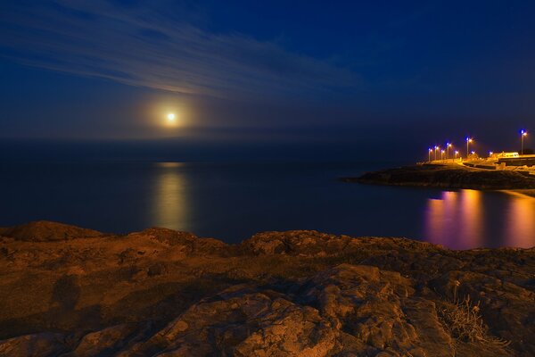 Księżycowa ścieżka nocą nad morzem