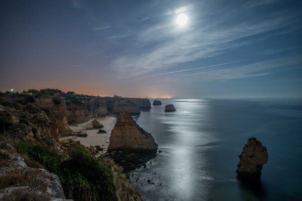 Felsen am Strand am Meer. Mond-Sternennacht