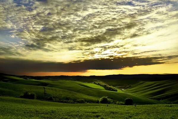 Collines vertes à la lumière du coucher de soleil orange