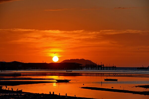 Red sunset on the sea. Boats in the bay