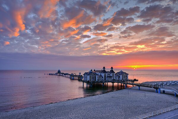 Pier with houses on the background of sunset