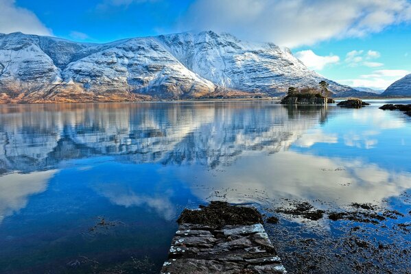 Reflejo de montañas cubiertas de nieve en el agua