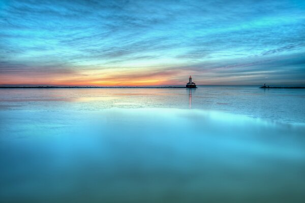 Paysage de miroir dans les tons d Azur. Mer au coucher du soleil