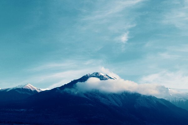 Picos nevados de montañas en las nubes