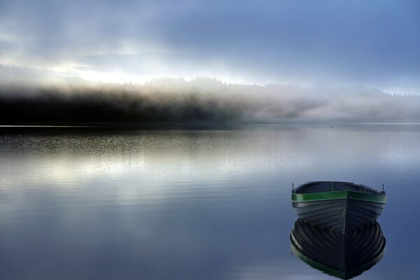 A boat on the lake. Morning fog