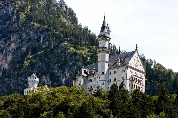 Château bavarois dans les montagnes avec la tour blanche