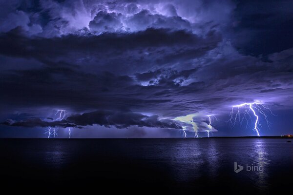 Thunderclouds with lightning in the night sky over the sea