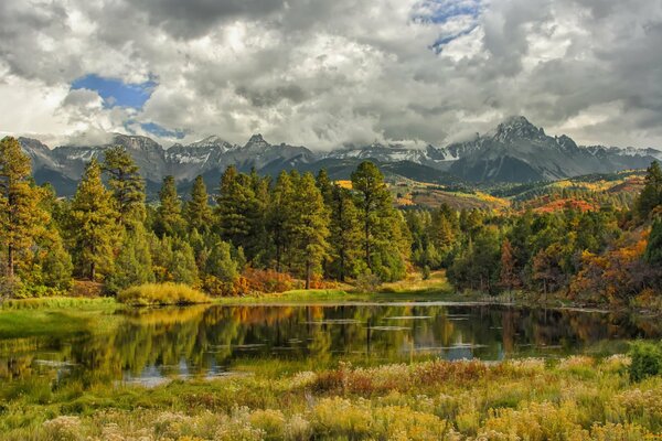 Lago vicino alla foresta e alle montagne in autunno