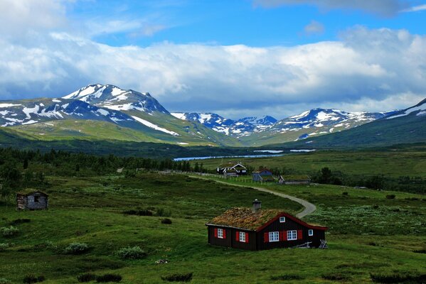 A house in the mountains with a blue sky