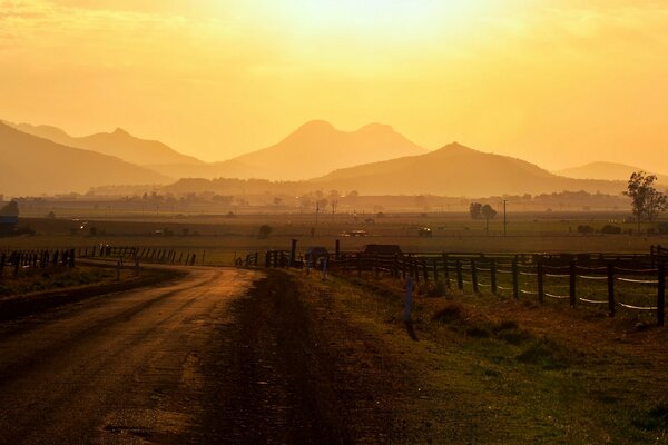 Una strada con un bellissimo paesaggio conduce attraverso una recinzione