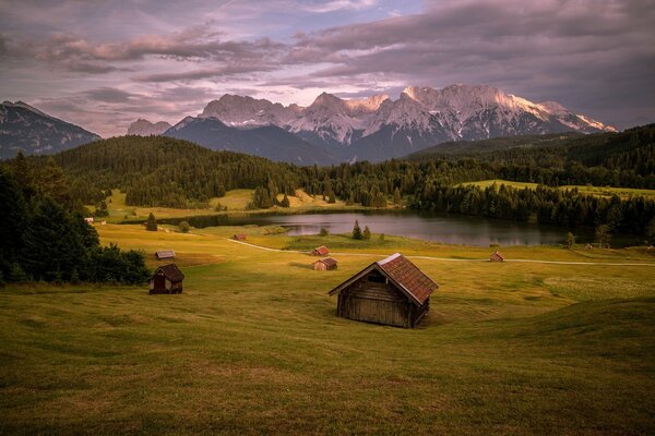 Ein Haus am See , eine Landschaft. Felder und Berge