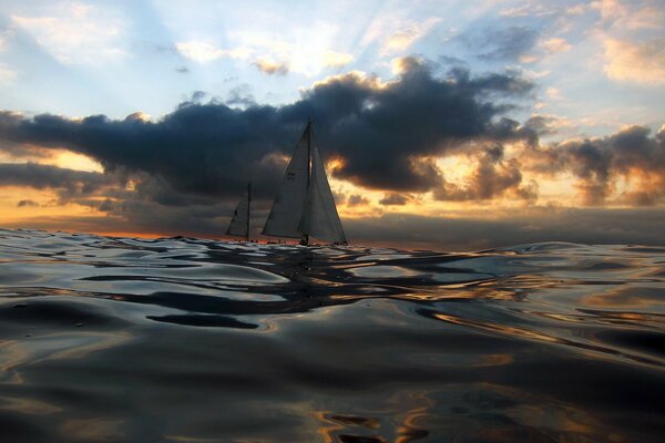 Mare al tramonto e barche a vela in lontananza