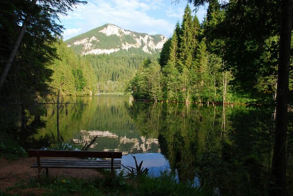 Banc au bord du lac avec vue sur les montagnes