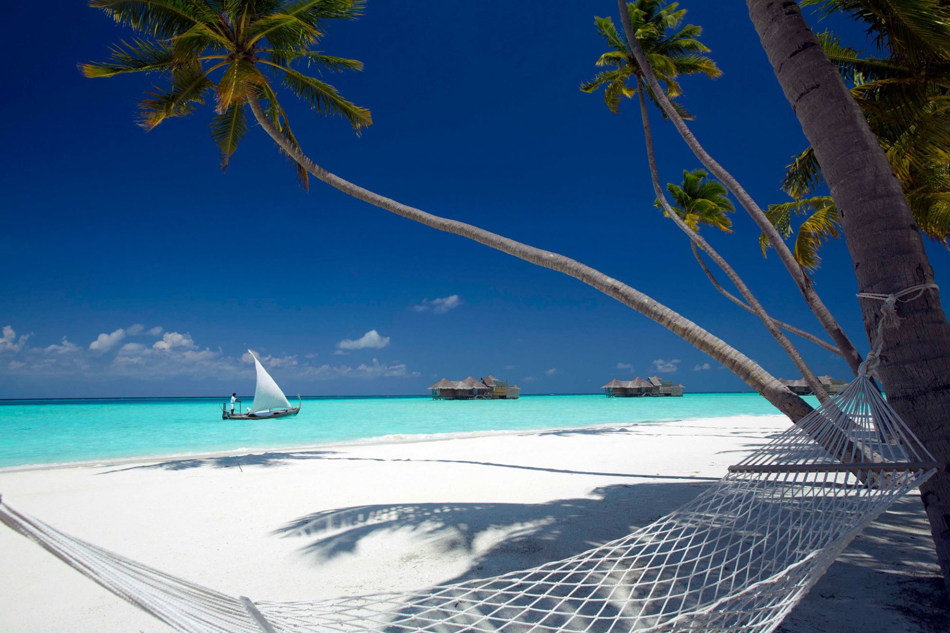 océan plage sable palmiers hamac bungalow bateau ciel nuages