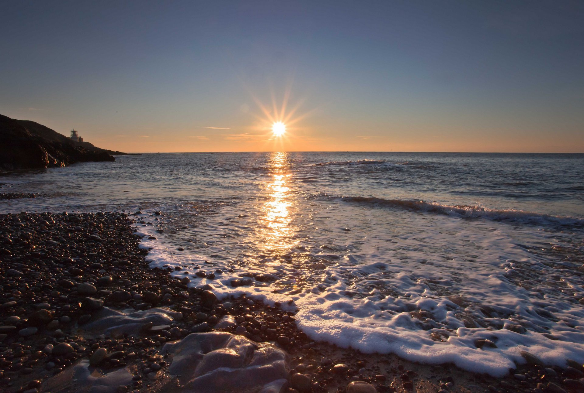 meer wellen schaum strand steine kiesel sonne dämmerung