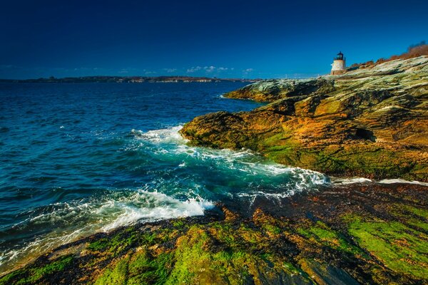 Phare sur la côte rocheuse. La mer est orageuse