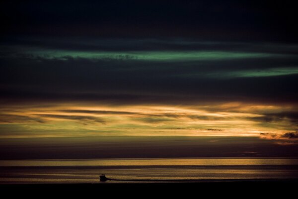 En el mar, las nubes se espesaron, pero el barco se ve al atardecer