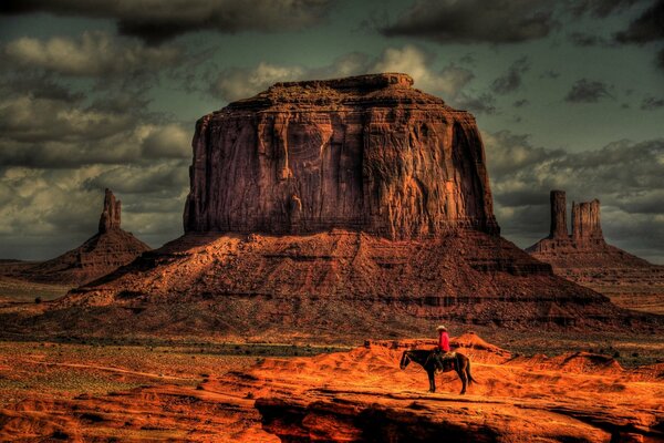 Cowboy auf einem Pferd bei Sonnenuntergang in der Wüste