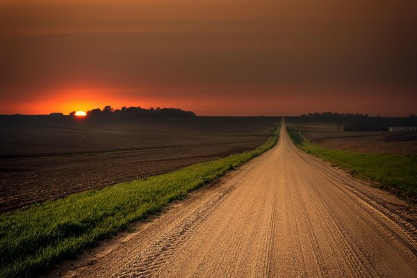 El camino que va a la distancia y el sol rojo