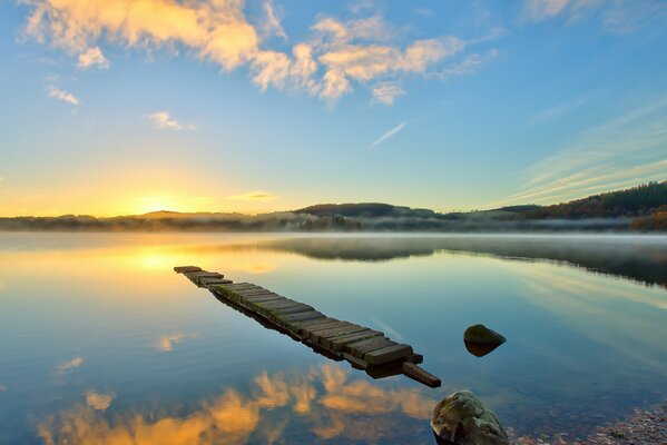 Lago al amanecer en la niebla