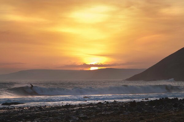 Morski Zachód słońca na plaży z falami