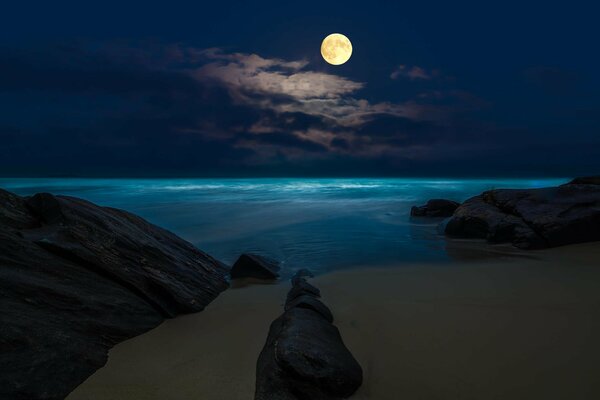 Vollmond an den Felsen in der Nacht am Strand