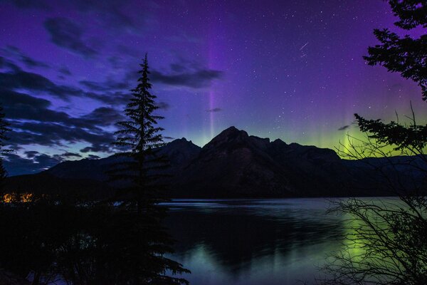 Nordlichter in der Nacht vor dem Hintergrund von Bergen und Seen