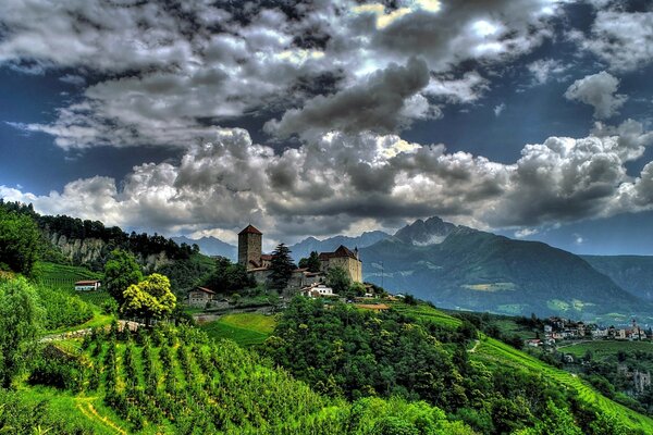 Nuvole scure che incombono sul castello sullo sfondo delle montagne