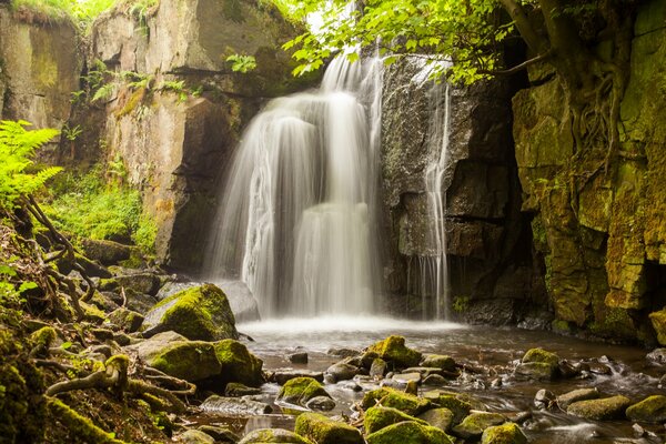 Mountain waterfall splashes on rocks