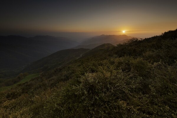 Hermosa puesta de sol en el fondo de las montañas