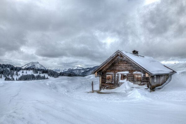 Casa in legno nelle montagne innevate