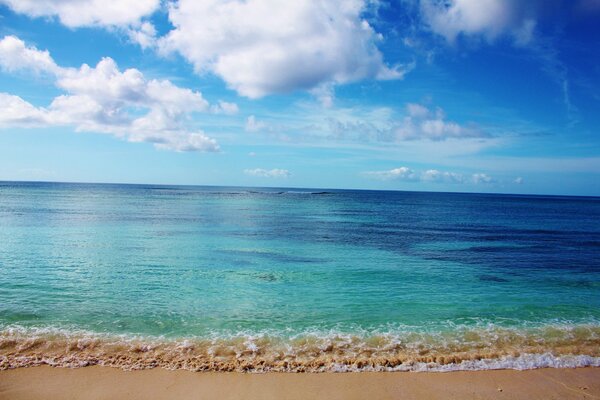 Les vagues de la mer bleue se confondent avec les nuages blancs