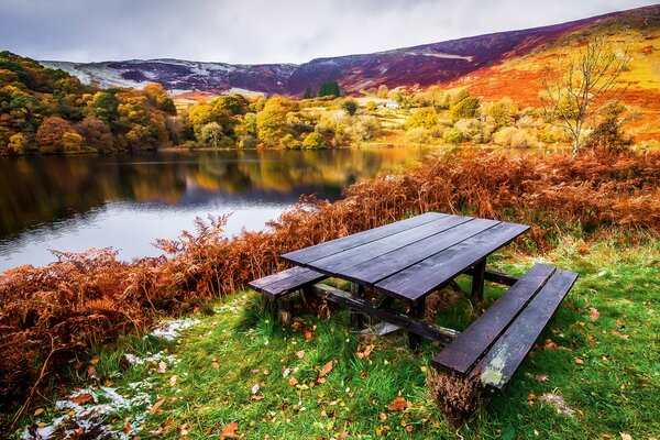 Paisaje de otoño mesa con bancos en la orilla del río